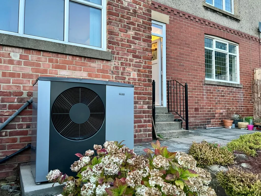 Close up of NIBE S2125 in garden against side of house in the UK