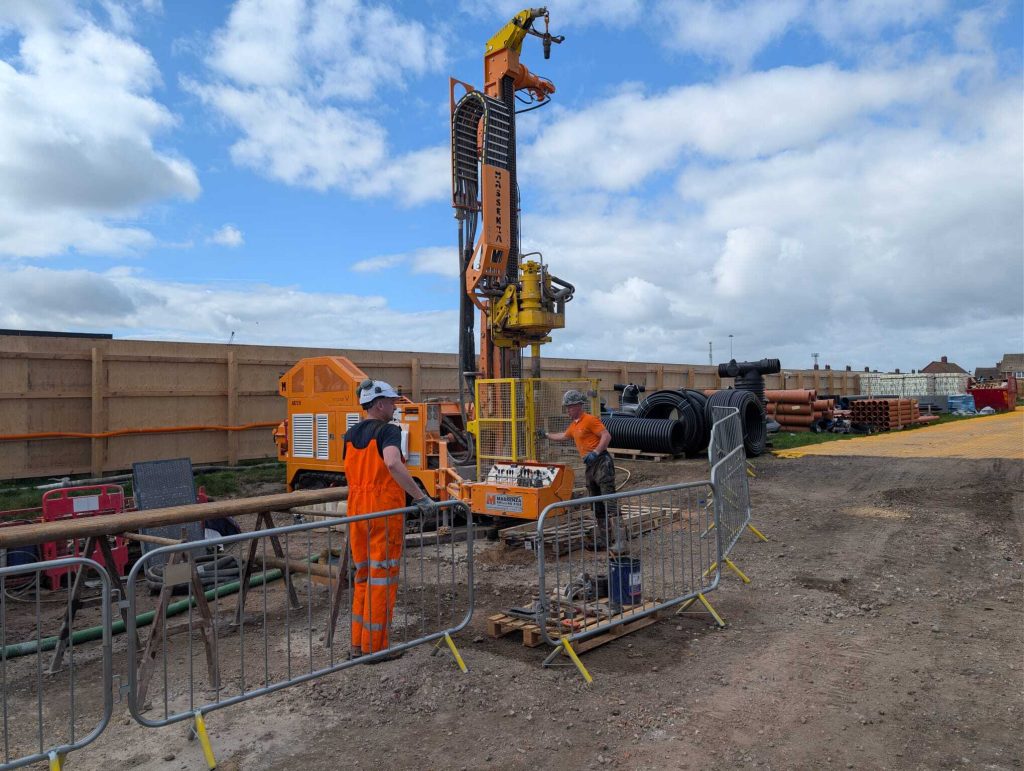 Two men drilling a borehole for a closed loop system